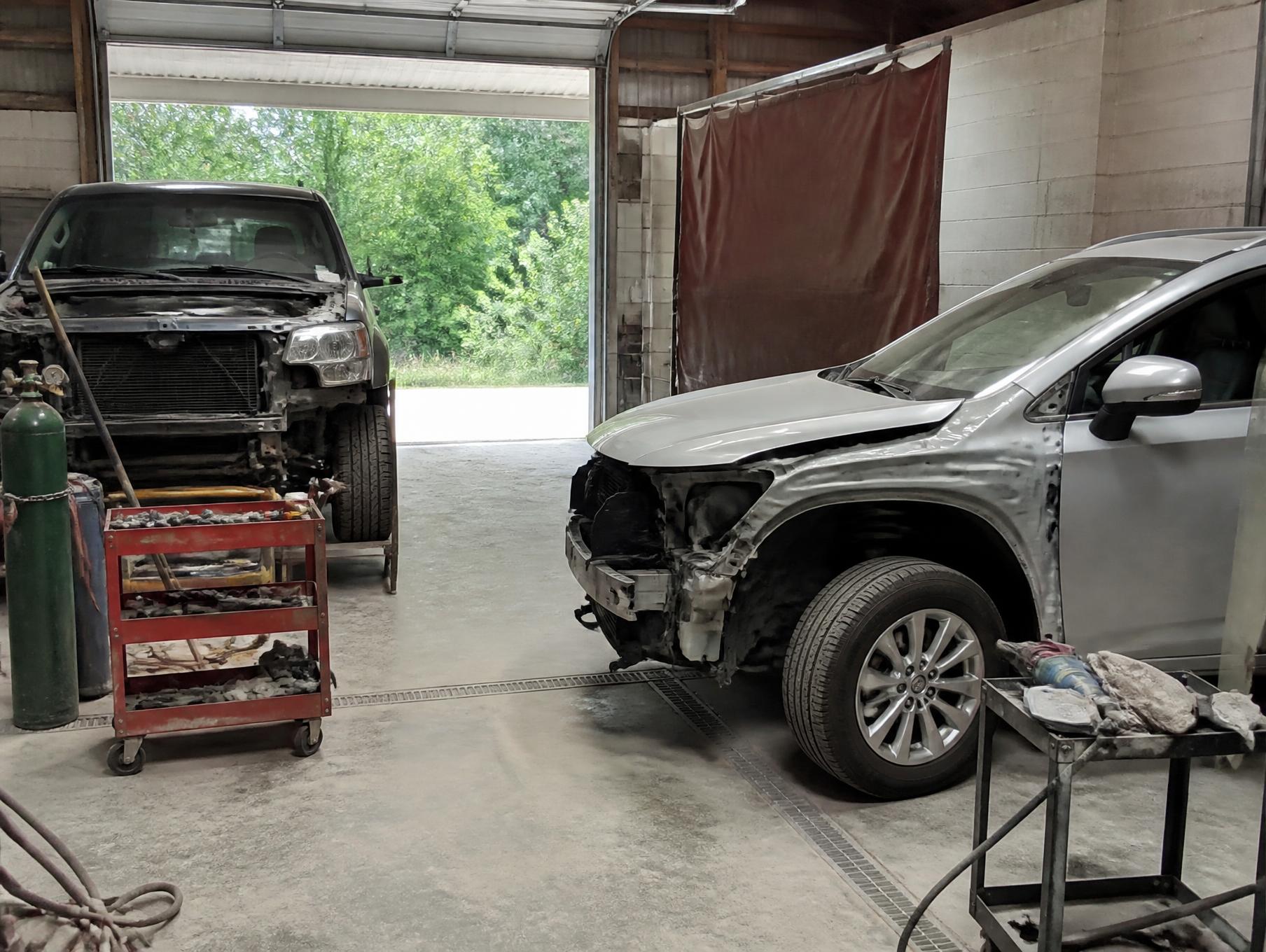 The repair bays at Paint Perfections Unlimited with vehicles in various stages of body work
